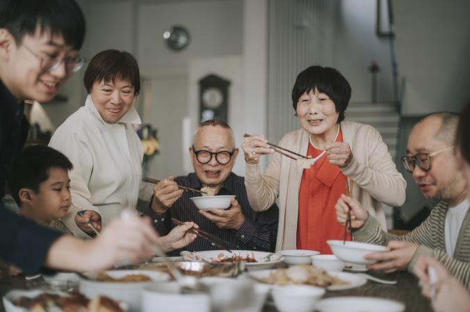 Several generations of a family share a meal at one table. Open larger view.